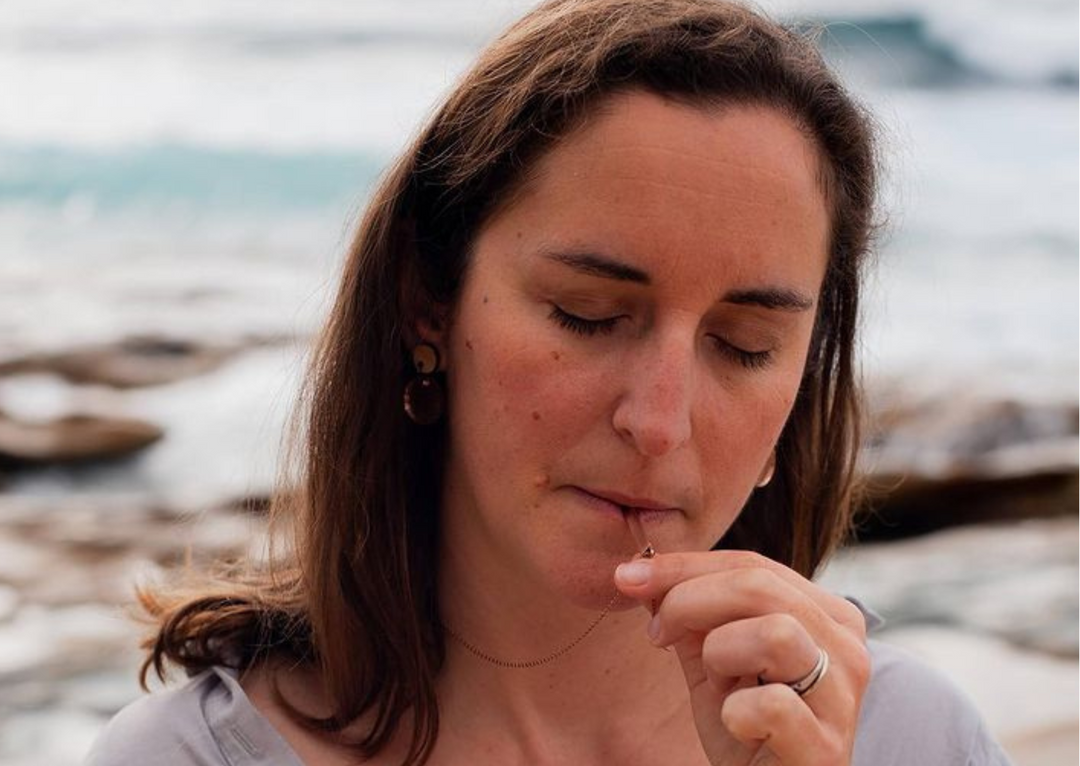 Woman doing mindful breathing using Breathe Into Peace Mindful Breathing Necklace