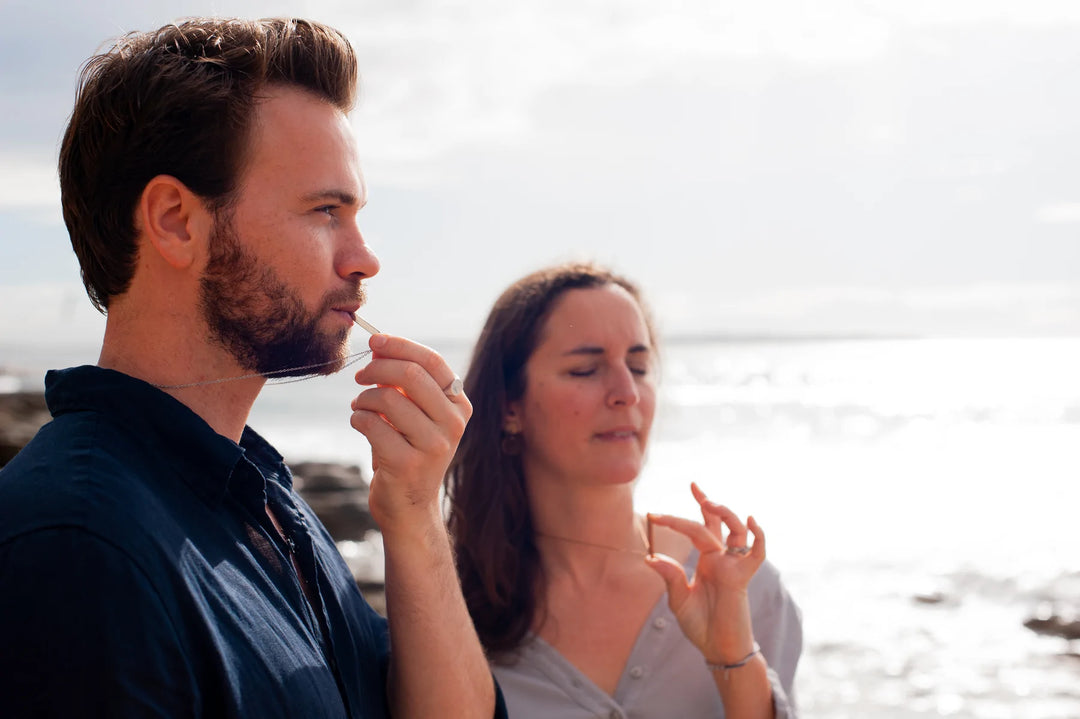 Parents in seashore doing mindful breathing using Breathe Into Peace Mindful Breathing Necklace